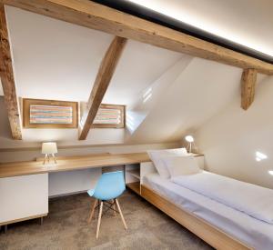 a bedroom with a bed and a desk and a chair at Hotel Kleis in Cvikov