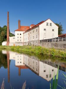 an old factory with its reflection in a body of water at Hotel Kleis in Cvikov