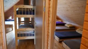 a room with bunk beds in a wooden cabin at Metsjärve puhkemaja in Puskaru