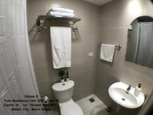 a bathroom with a toilet and a sink at Jazz Makati Luxury Apartment in Manila