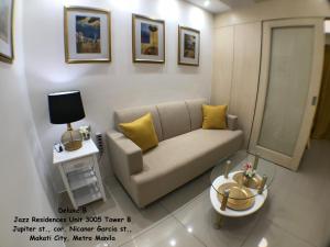uma pequena sala de estar com um sofá e uma mesa em Jazz Makati Luxury Apartment em Manilla