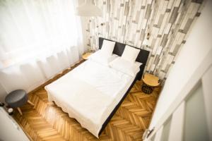 a white bed sitting next to a white wall at Mansarda Noclegi in Września