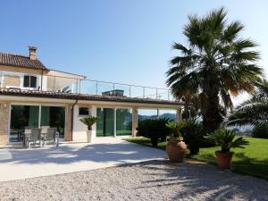 uma casa com portas de vidro e uma palmeira em Villa Belvedere Degli Ulivi em Osimo