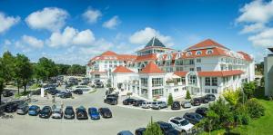 a large building with cars parked in a parking lot at Grand Lubicz Uzdrowisko Ustka in Ustka