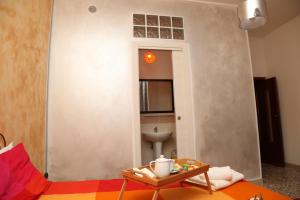 ein Wohnzimmer mit einem Sofa und einem Tisch in der Unterkunft Viale Italia 41: I migliori anni in Sassari