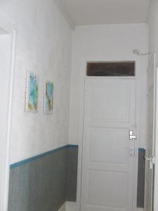 een kamer met een witte deur en twee foto's aan de muur bij chambre d'hôtes du Valvion in Beauquesne
