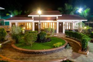 a house with a garden in front of it at night at Paradise Villas & Resort in Alibaug