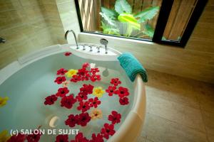 名護的住宿－Bougain Terrace Resort Ta-chi House，浴缸里布满红色和黄色的花卉