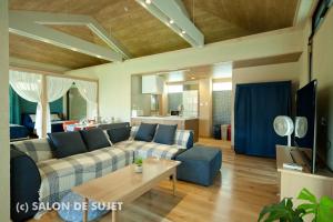ein Wohnzimmer mit einem Sofa und einem Tisch in der Unterkunft Bougain Terrace Resort Ta-chi House in Nago