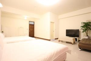 a bedroom with two beds and a flat screen tv at Nice Comfortable Homestay in Taitung City