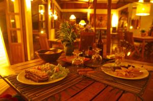 Nature Lodge في دييجو سواريز: طاولة خشبية عليها طبقين من الطعام