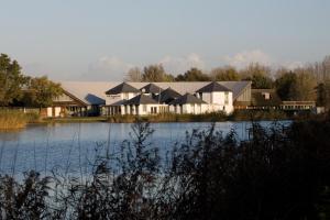 una fila di case vicino a un corpo d'acqua di Fletcher Hotel - Resort Spaarnwoude a Velsen-Zuid
