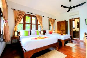 1 dormitorio con 2 camas y ventana en Maisons Wat Kor en Battambang