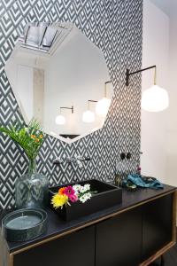 a bathroom with a black counter with flowers in a vase at Loft Greneta in Paris