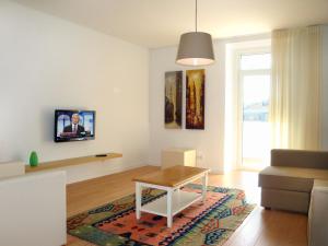 a living room with a table and a tv at My Place - Lisbon Lounge Suites in Lisbon