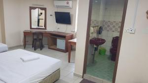 a hotel room with a bed and a desk and a mirror at Prime Hotel in Limbang