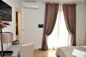 - une chambre avec un lit et une fenêtre avec des rideaux dans l'établissement Il Casale Della Gioia, à Melfi