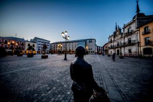 a man walking down a street in a city at Hotel Aroi Bierzo Plaza in Ponferrada