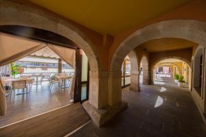 an outdoor patio with arches and tables and chairs at Hotel Aroi Bierzo Plaza in Ponferrada