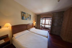 a bedroom with two beds and a window at Hotel Aroi Bierzo Plaza in Ponferrada