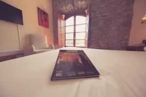 a book is sitting on top of a bed at Hotel Aroi Bierzo Plaza in Ponferrada