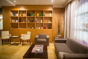 uma sala de estar com um sofá e cadeiras e uma estante de livros em Hotel Aroi Bierzo Plaza em Ponferrada