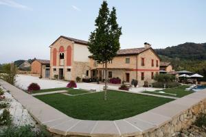 a large building with a tree in the middle of a yard at Agriturismo La Ratta in Vernasca