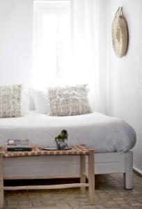 a bedroom with a bed with a table next to it at Hôtel Emeraude Essaouira in Essaouira