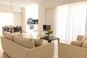 a living room with a couch and a table with flowers at Elysia Park in Paphos