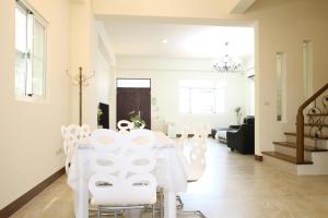 una sala da pranzo bianca con tavolo e sedie bianche di Nice Comfortable Homestay a Città di Taitung