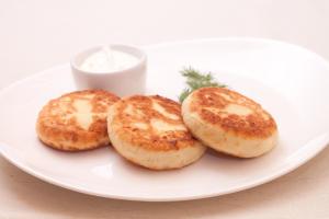 three biscuits on a white plate on a table at Mini gostinitsa HOSTEL in Odesa