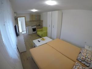 een woonkamer met een tafel en een groene bank bij Apartman Hrupjela in Trebinje +4 foto's