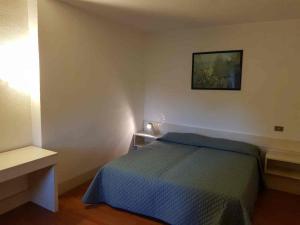 1 dormitorio con 1 cama y una foto en la pared en Appartamento Privato Club Primula, en Pescasseroli