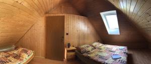 a bedroom with two beds in a wooden attic at Chalupa Podlesí in Podlesí