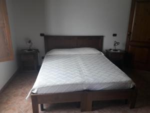 1 cama en un dormitorio con 2 mesitas de noche y 2 mesas en Terrazze sul frido en Viggianello