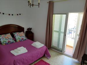 サンルーカル・デ・バラメダにあるMalandarのベッドルーム1室(紫色のベッド1台、タオル付)