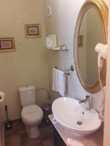 a bathroom with a sink and a toilet and a mirror at Hotel Boutique Monaco in Bucharest