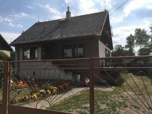 ein Haus mit einem Tor und Blumen davor in der Unterkunft Ubytování v rodinném domě in Hejnice