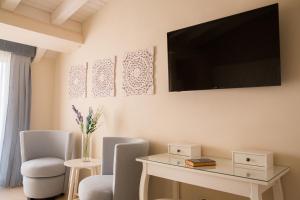 sala de estar con mesa y TV en la pared en Attico, en Canicattì