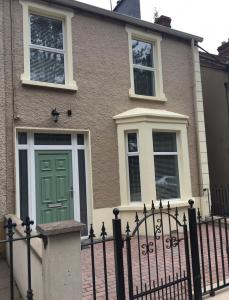 a house with a green door and a fence at Grange House in Omagh