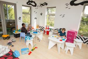 three children sitting at tables in a room with toys at Old Mac Daddy in Botrivier