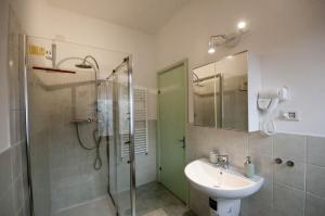 een badkamer met een glazen douche en een wastafel bij La Rosa di Orvieto in Orvieto