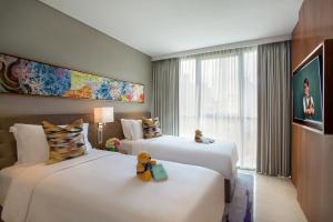 雅加达Ascott Sudirman Jakarta的两间位于酒店客房的床,上面有泰迪熊