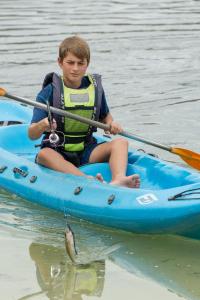 a young boy in a blue kayak in the water at Old Mac Daddy in Botrivier