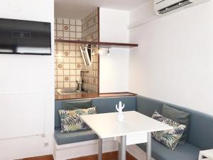 ein Esszimmer mit einem weißen Tisch und einer Bank in der Unterkunft Apartamentos Albertos in Santa Eulària des Riu