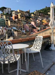 two chairs and a table on a balcony with a city at Ai Pesci Room Rental in Riomaggiore