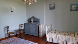 a bedroom with a bed and a table and chairs at Chambres d'Hôtes Larrey in Audignon