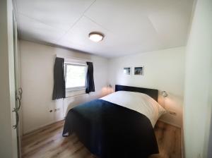 a bedroom with a bed in a room with a window at Vakantiehuis Fenna in Terherne