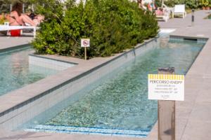 a swimming pool with a sign in front of it at Hotel Le Axidie in Vico Equense