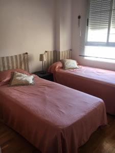 een kamer met 2 bedden, een raam en een raam bij Apartamento Cabo Mar in El Campello